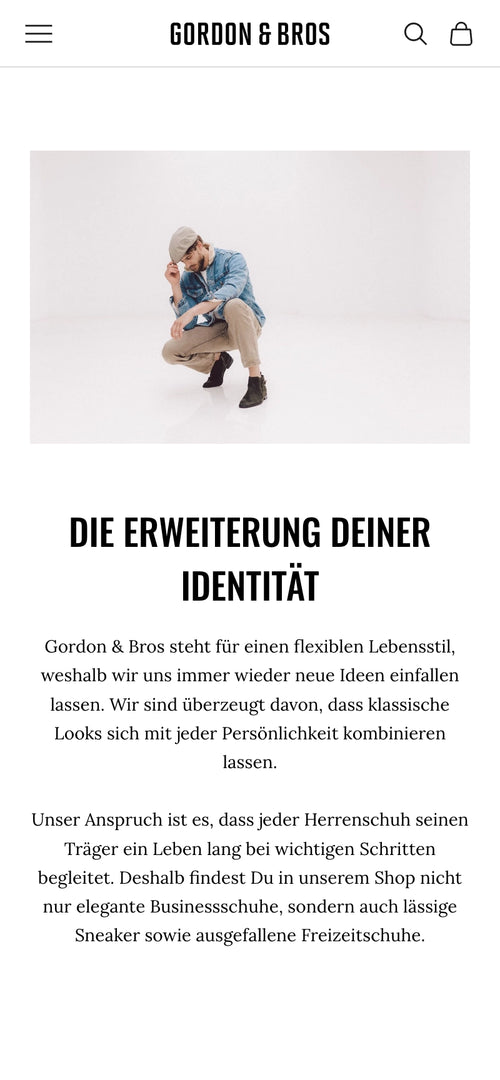 Mann in hellbrauner Hose und blauer Jacke mit Kappe hockt, weißer Hintergrund.