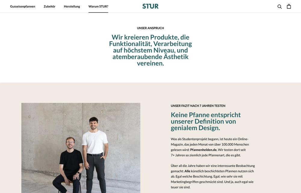 Zwei Personen vor grauer Wand mit Text zu Designphilosophie.