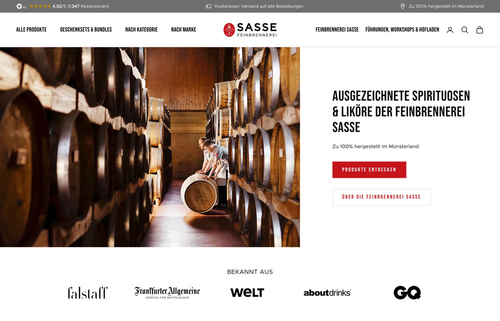 Person rollt Holzfass durch Lagerhalle mit Sasse-Logo an der Wand.