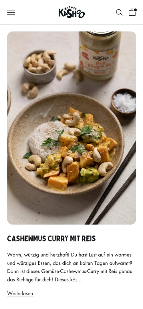 Cashew-Curry mit Reis, garniert mit Basilikum und Cashewnüssen, daneben Cashewmusglas.