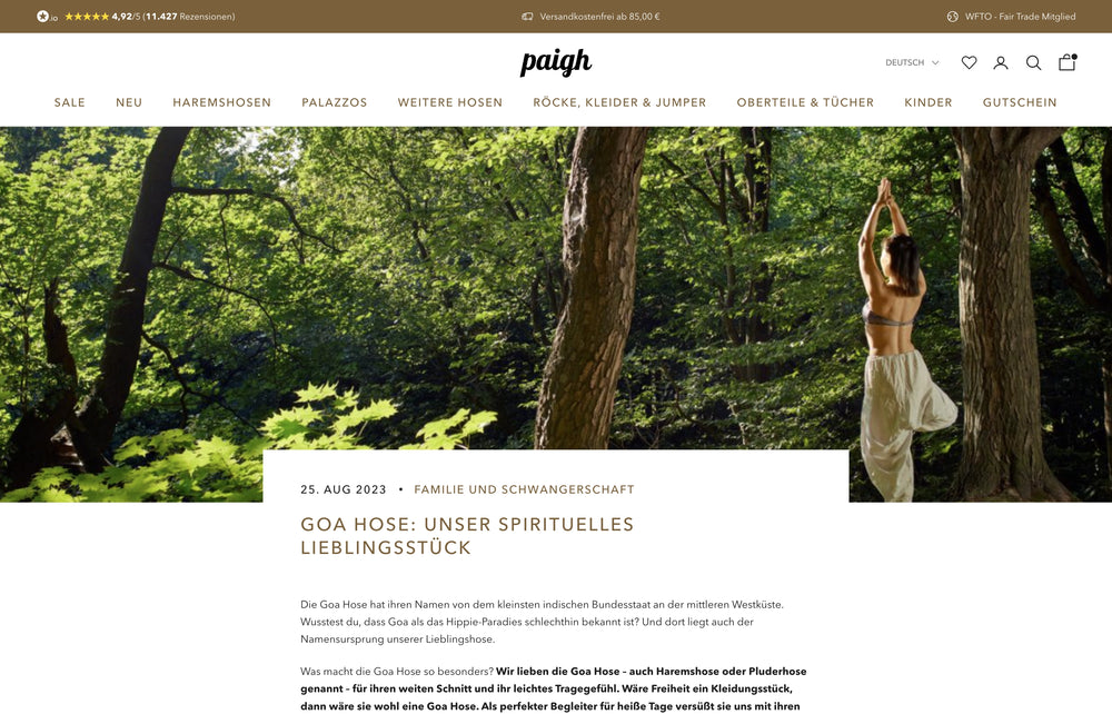 Frau im Wald mit nach oben gestreckten Armen, trägt ein Kleid.
