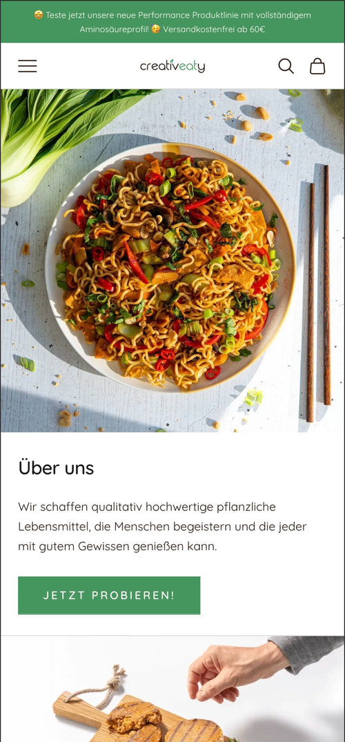 Nudelgericht mit frischem Gemüse auf weißem Teller. Text über hochqualitative, pflanzliche Lebensmittel.