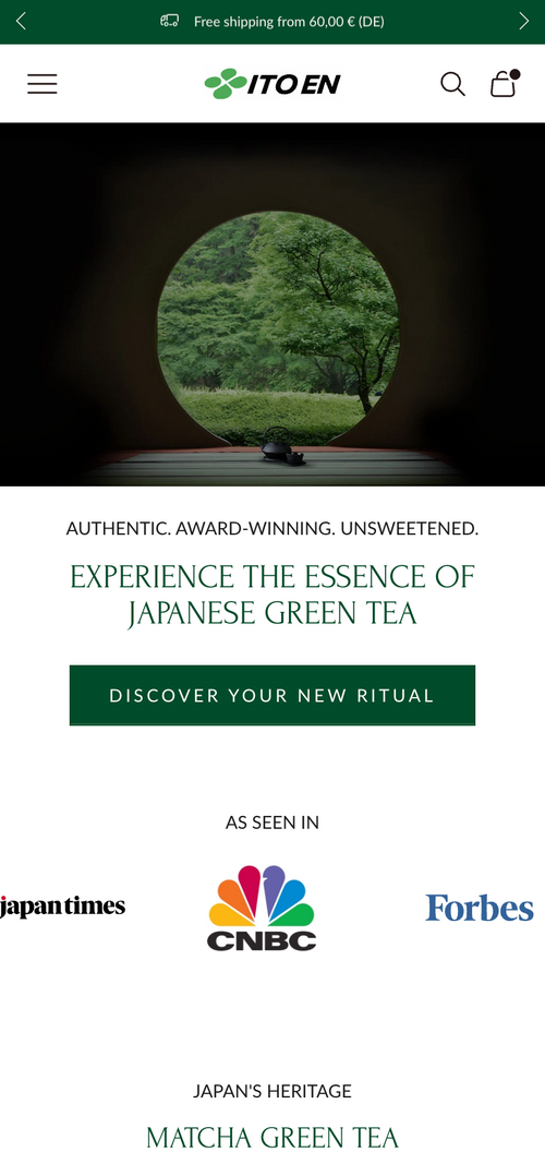 Teekanne vor rundem Fenster mit Blick auf eine grüne Landschaft.