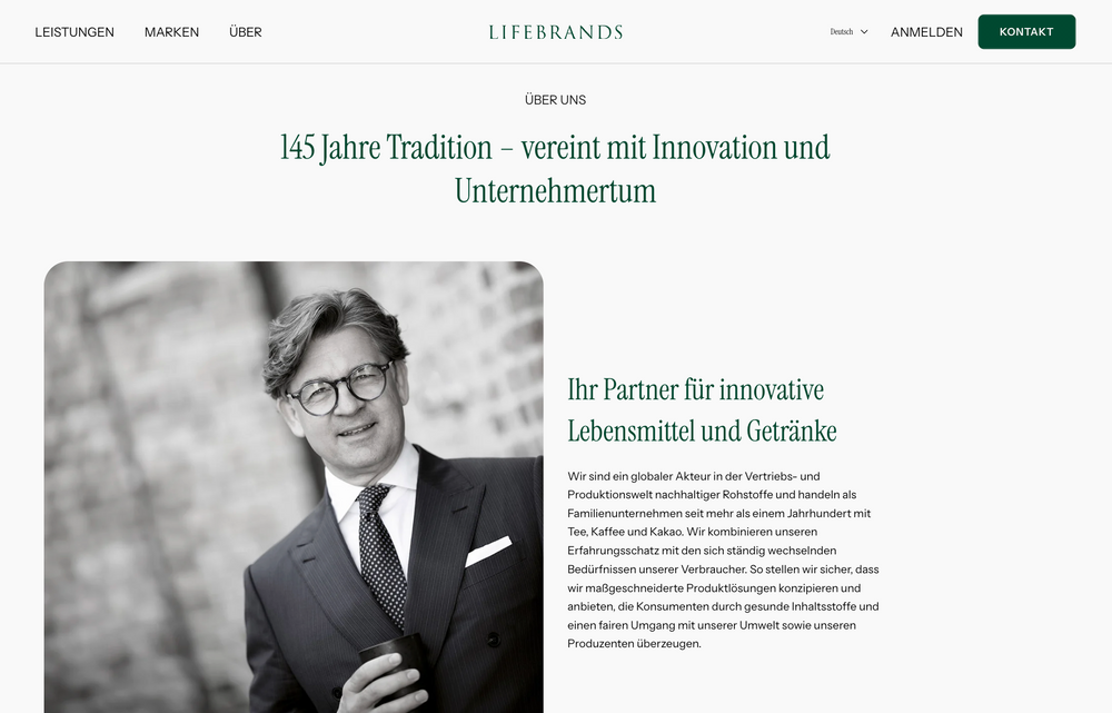 Schwarz-Weiß-Foto eines Mannes mit Brille, Anzug und Krawatte.